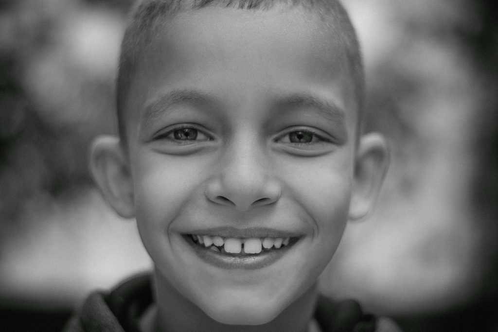 Young child smiling before an emergency pediatric dental visit for urgent dental care